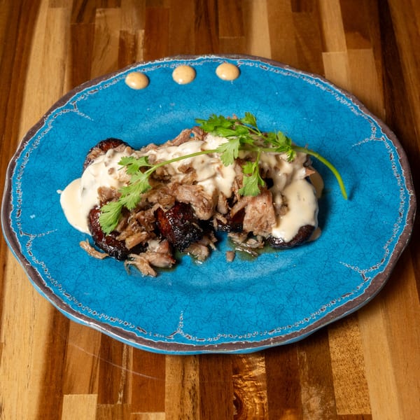 Panzu Brewery's dish with shredded meat, creamy sauce, and cilantro on a blue plate.